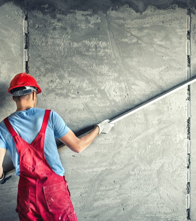 industrial worker with plastering tools renovating a house. builder worker plastering facade